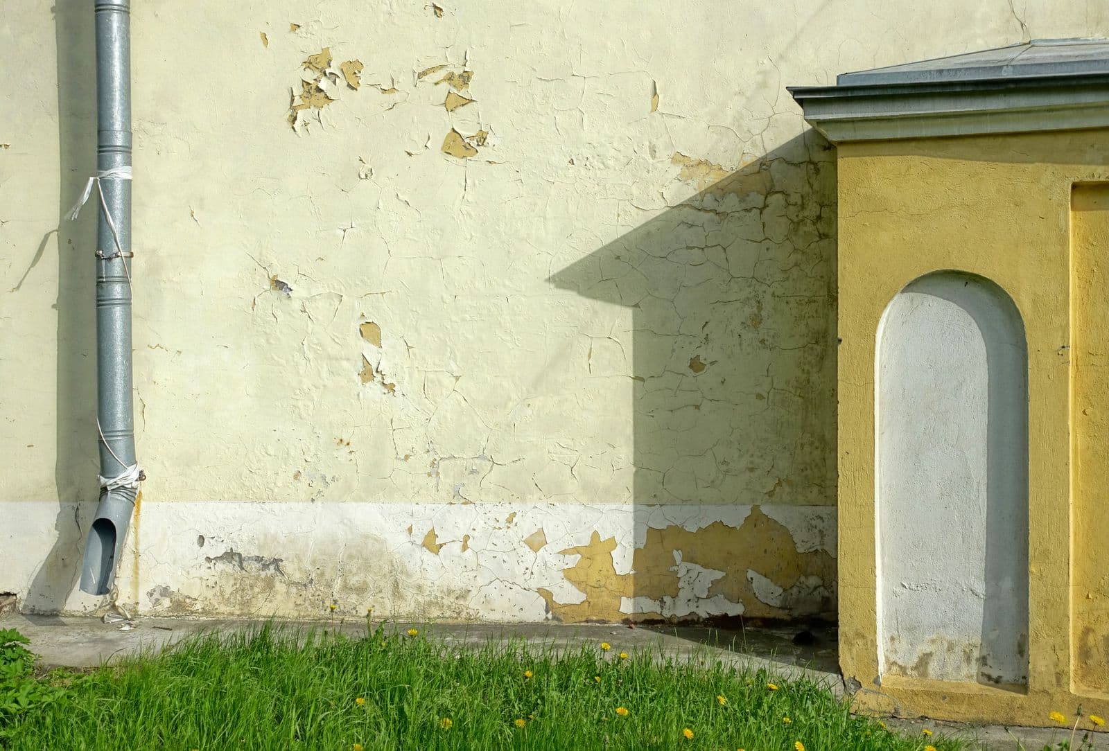 Traces d’humidité et peinture dégradée en pied de mur